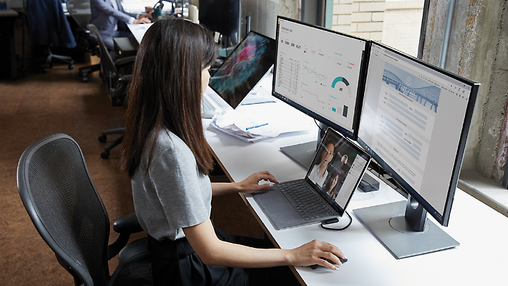 Uma pessoa sentada à secretária a olhar para um diagrama de rede físico no monitor de um computador