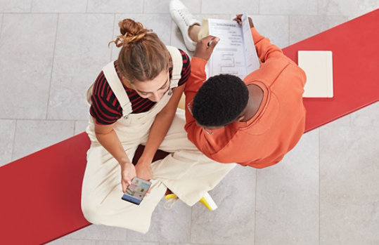 Twee mensen die naar foto's kijken die zijn opgeslagen in de OneDrive-app op een mobiele telefoon.