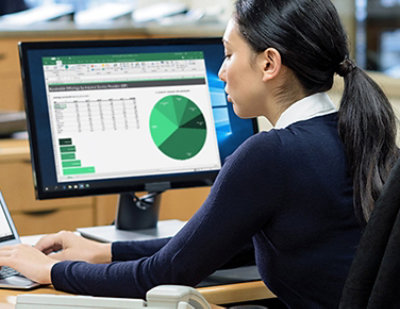 A woman sitting at a desk using a computer.