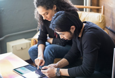 Two people at a table looking at a device