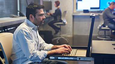 Ένα άτομο που κάθεται σε ένα γραφείο και χρησιμοποιεί έναν φορητό υπολογιστή.