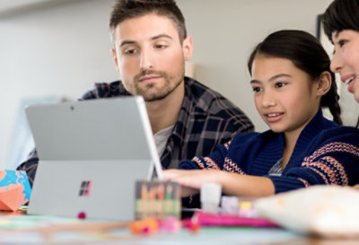 Dos adultos y un niño usando un Surface Pro