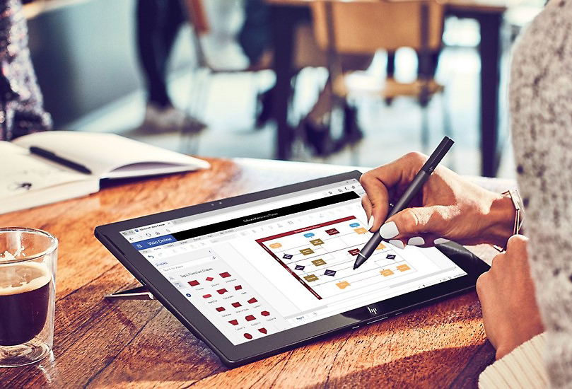 A person using a pen to add comments to a Visio diagram open in a web browser on a tablet.