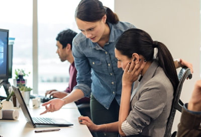 עובד IT שעוזר לעמית לפתור בעיות במחשב שולחני