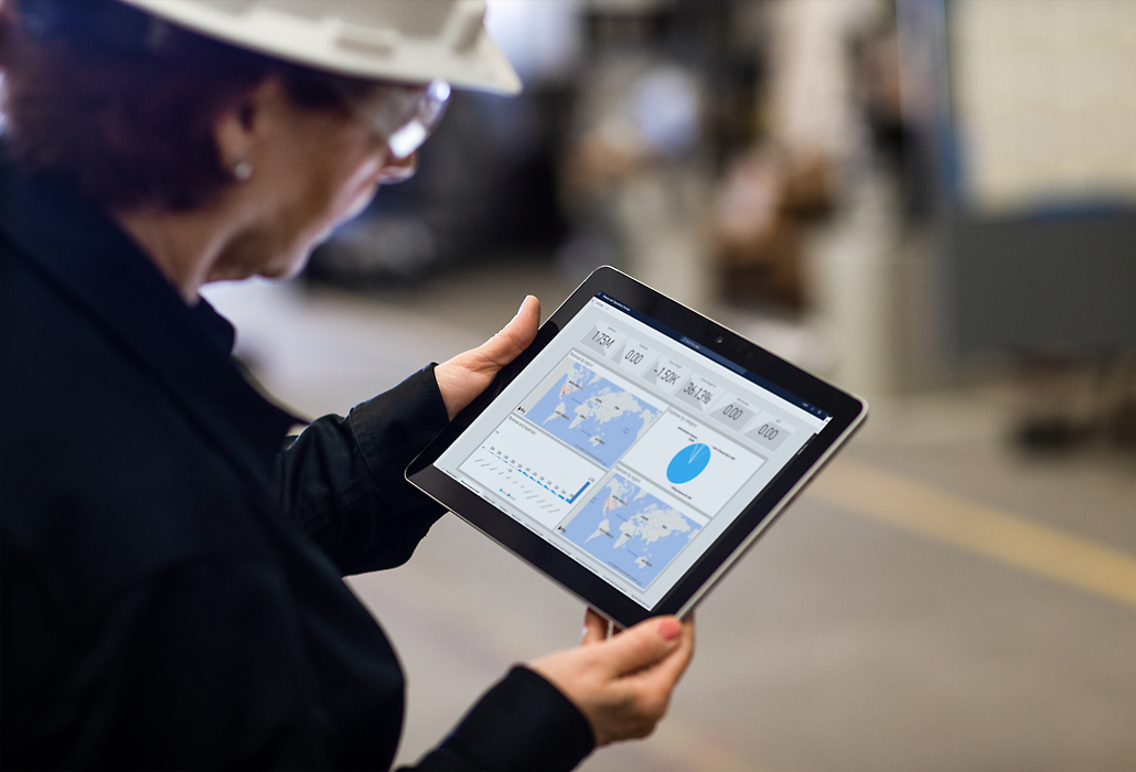 Person wearing a hard hat looking at data on a tablet device