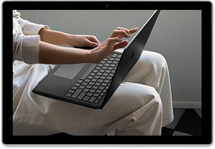 Fotografia di una persona seduta con un portatile che tocca lo schermo