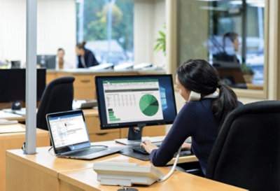 A person working at a desk while on the phone