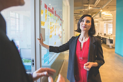 Two people talking in an office hallway