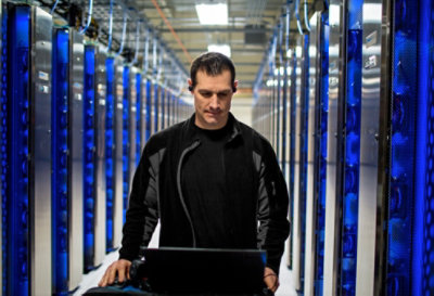 A person working on a laptop in a data center