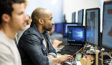 Two people in an office looking at a device
