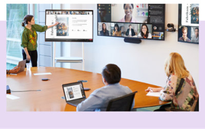 A presentation being given on a large screen in a conference room with a Teams call on another large screen.