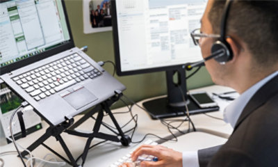 Hombre con auriculares trabajando en una estación de trabajo portátil.