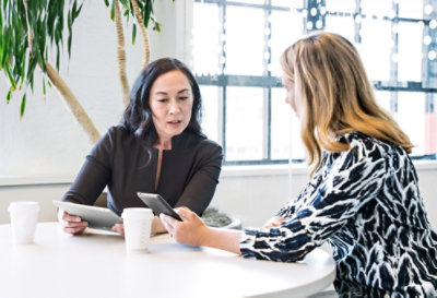 Two people talking at a round table in an office