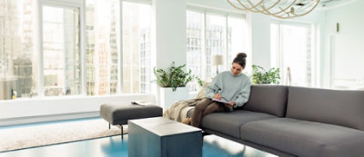 A woman sitting on a couch writing on a paper.