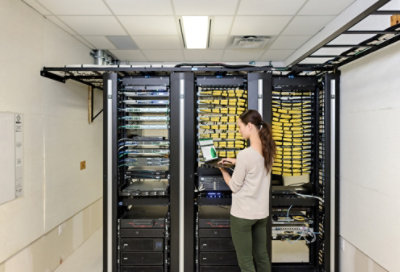 站在刀鋒伺服器前使用平板電腦的人。