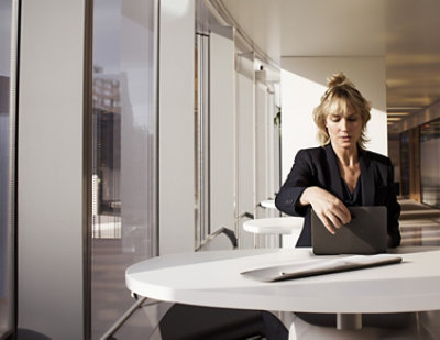 A woman in a suit holding a laptop.