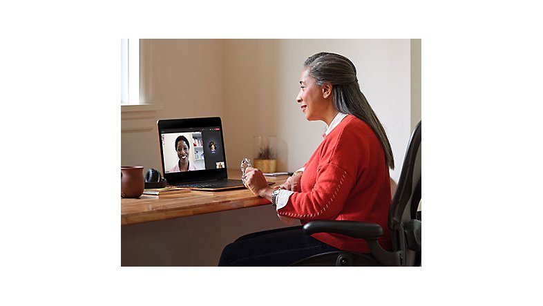 A person sitting at a desk engaged in a Teams video call with a medical provider on a laptop