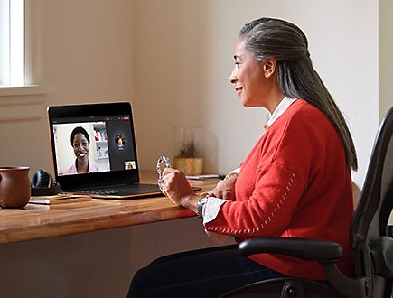 A person sitting at a desk engaged in a Teams video call with a medical provider on a laptop