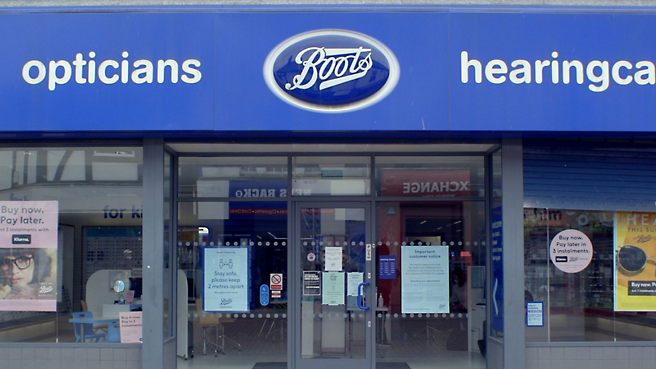 The front of a boots store with a blue sign.