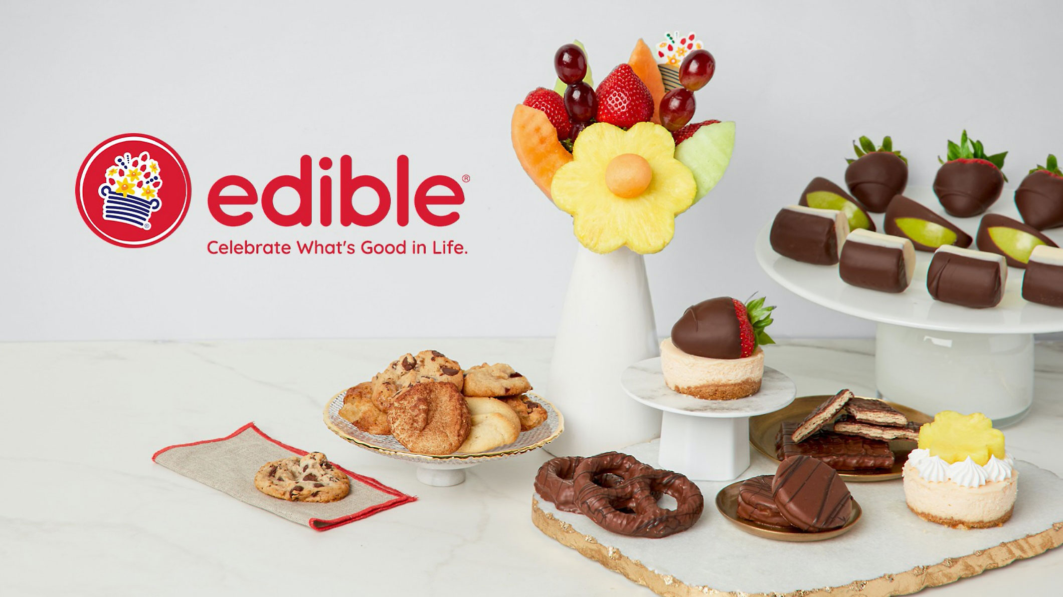 O masă plină de deserturi și prăjituri cu cuvântul „edible” pe ea.