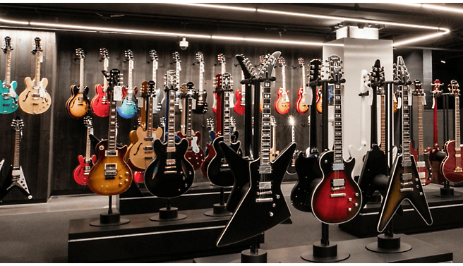 Many guitars are on display in a store.