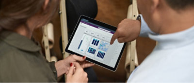 Un hombre y una mujer mirando una tableta con un grafo.