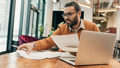 A man works at a table in a shared office space.