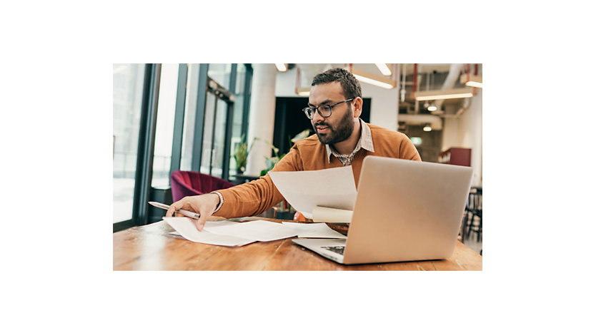 A man works at a table in a shared office space.