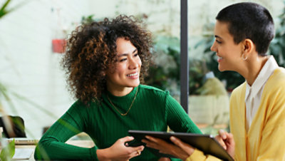 Happy business colleagues having discussion over tablet