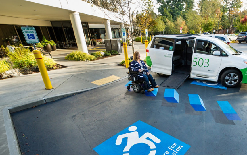 A woman in a wheelchair prepares to board a Microsoft Shuttle