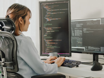 A woman sitting at a desk working on a computer.