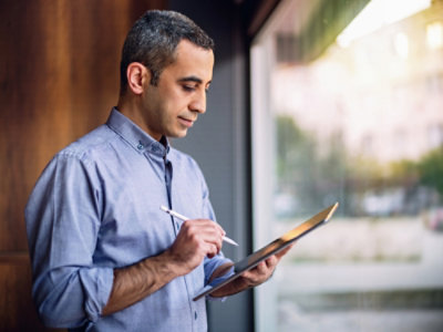 A person holding a tablet and a stylus.