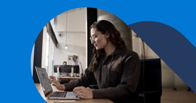 Une personne travaille sur un ordinateur portable à un bureau dans un bureau décloisonné