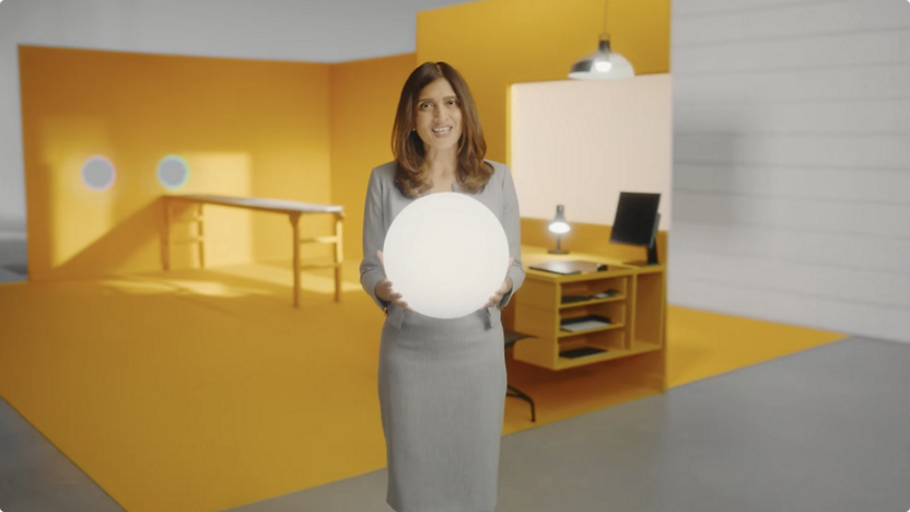 A woman holding a white ball in an office.