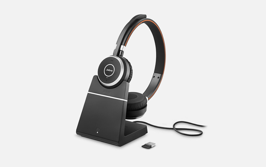 Jabra Evolve 65 Wireless Headset on a dock with a charging cable.