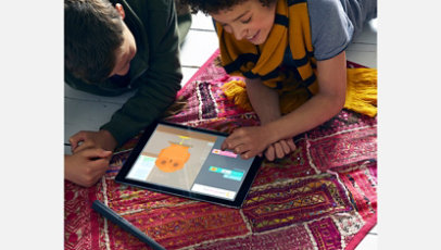 Two kids play a Harry Potter coding game on their tablet.