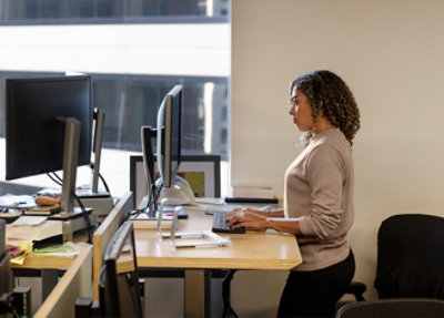 A woman with curly hair using a laptop.