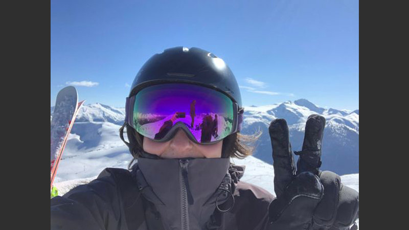 Kiah McGeer vêtue d'un équipement de ski prend un selfie avec des montagnes enneigées en toile de fond