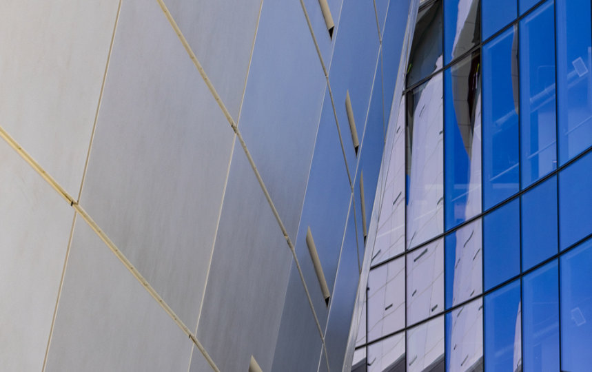 Close-up of modern building with glass and metal panels.