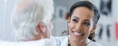 A woman with long curly hair looking at a row of computer monitors.