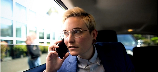 En kvinen med briller som snakker i en mobiltelefon.