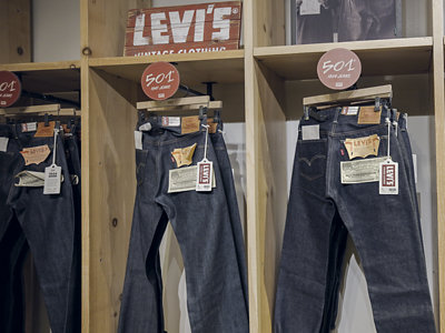 Levi’s 501 jeans displayed on wooden retail shelves.
