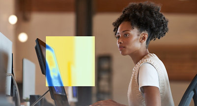 A person with curly hair looking at a computer screen.