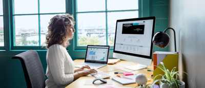 Une femme assise à un bureau travaillant sur son ordinateur.