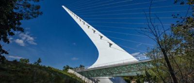 A white bridge with wires with Sundial Bridge at Turtle Bay in the background