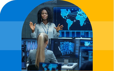 En person, der taler til et kontor med mange skærme, der viser datakort