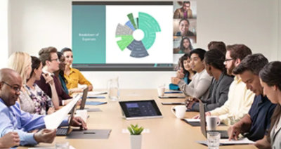 Fotografi som visar en presentation inför människor i ett stort sammanträdesrum.