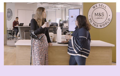 Deux employés discutant autour d’un café dans les bureaux de Marks & Spencer