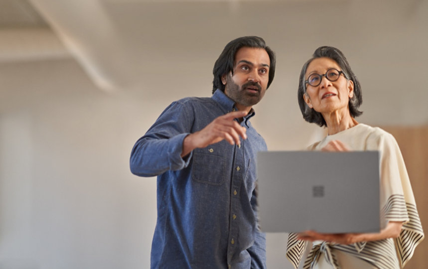Man and woman pointing and looking at something in office