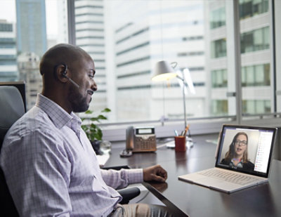 A man in a headset looking at a laptop screen.